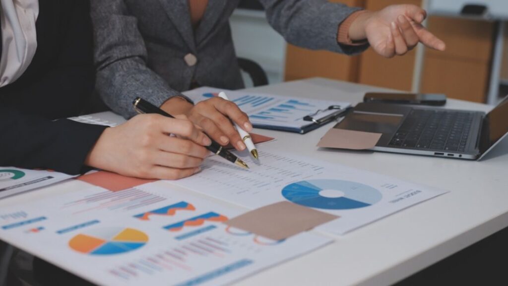 Business professionals analyzing BI total cost of ownership reports and charts for enterprise business intelligence investment planning