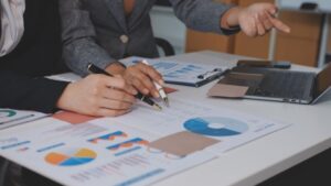 Business professionals analyzing BI total cost of ownership reports and charts for enterprise business intelligence investment planning